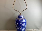 une image représentant un vase bleu et blanc sur lequel est posée une lampe