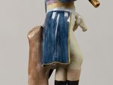 a figurine of a man sitting on a tree stump