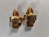 two pieces of gold are sitting on top of a white surface
