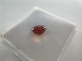 a close up of a red diamond sitting on top of a white surface