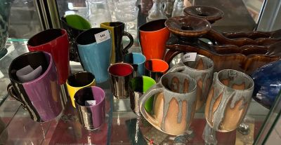 de nombreuses tasses de différentes couleurs exposées dans une vitrine