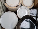 many plates and bowls sitting in a box on the floor