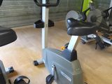 a gym room with a row of stationary exercise bikes