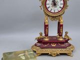 a small clock sitting on a table next to a small box