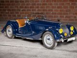a blue car that is parked in front of a brick wall