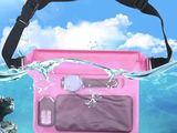 un sac rose imperméable, auquel est attaché un téléphone portable, flottant dans l'océan