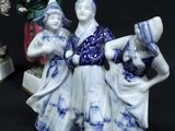 three figurines of people sitting on a black surface