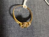 un gros plan d'une bague en or posée sur un tissu bleu