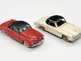 deux voitures jouets assises l'une à côté de l'autre sur une surface blanche