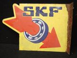 un panneau sur lequel est inscrit « SKF » et sur lequel figure une flèche