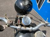une moto garée sur un parking, avec un panneau en arrière-plan
