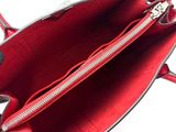someone is holding a red purse with a zipper on it
