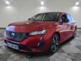 une voiture rouge est garée dans une grande pièce au sol en damier