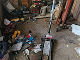 a pile of junk in a garage with a shovel and other tools