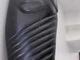 a black vase that is on the wall next to a shelf