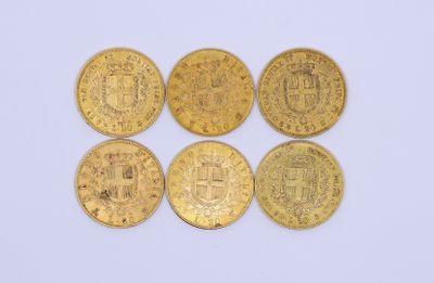 four gold coins with a coat of arms on them on a white surface