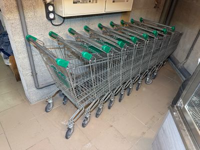 many shopping carts lined up in a row in a store