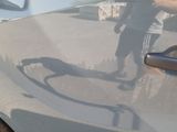 a man standing next to a car with a shadow on the door