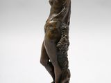 a bronze statue of a woman holding a bird on a pedestal