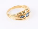 Gros plan sur une bague en or ornée de pierres bleues