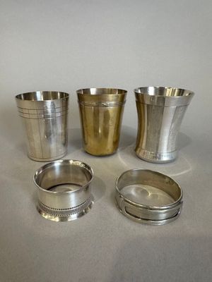 Trois coupes en argent sont posées les unes à côté des autres sur une table.