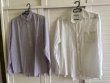 two shirts hanging on a clothes rack in a room