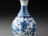 vase bleu et blanc orné de fleurs et de vrilles sur fond noir
