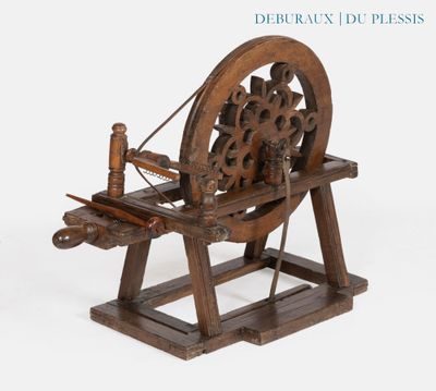 un rouet en bois exposé sur un fond blanc