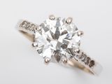 a close up of a diamond ring on a white surface