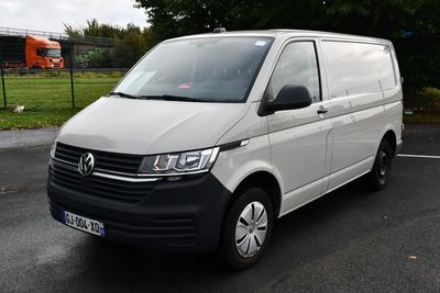La camionnette blanche est garée sur le parking près de la pelouse.