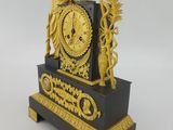 a gold and black clock with a statue on top