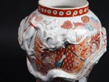 a white vase with a dragon on it on a black background