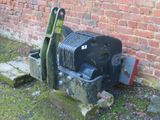 a black machine sitting on the ground next to a brick wall