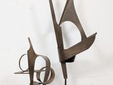 two metal sculptures that are sitting on a white surface