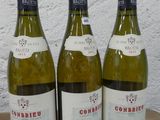 trois bouteilles de vin posées sur une table en bois