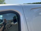 a man taking a picture of himself in the side mirror of a truck
