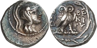 a close up of a coin with an owl on it