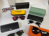 Plusieurs paires de lunettes de soleil, des lunettes de soleil et un étui sont disposés sur une table