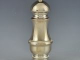 a silver pepper shaker with a gold top