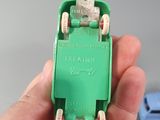 a person holding a green toy car in their hand