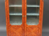 une armoire ancienne en bois avec des portes vitrées et un plateau en marbre
