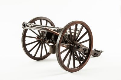 a small model of a cannon on a white surface