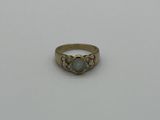 une bague en or avec une pierre verte au centre