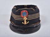 un chapeau noir orné d'une ancre dorée et d'un ruban