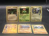 quatre cartes Pokémon différentes exposées dans une vitrine
