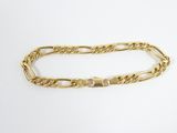 a close up of a gold chain bracelet on a white surface