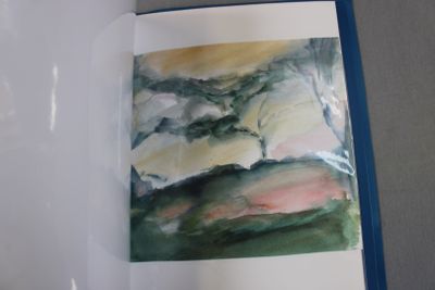 an open book with a picture of a landscape in it