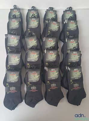 plusieurs paires de chaussettes noires pour homme suspendues à un mur