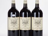 trois bouteilles de vin sont alignées sur une surface blanche