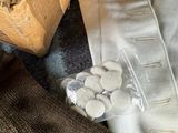 a box of pills sitting on a bed next to a pair of pants
